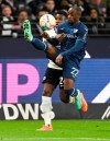 Frankfurt's Aurelio Buta, left, and Bochum's Christopher Antwi-Adjei fight for the ball during the German Bundesliga soccer match between Eintracht Frankfurt and VfL Bochum at the Deutsche Bank Park stadium, in Frankfurt, Germany, Friday March 31, 2023. (Arne Dedert/dpa via AP)