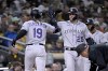 Colorado Rockies' Charlie Blackmon, left, gets congratulations from C.J. Cron after hitting a two-run home run against the San Diego Padres during the fifth inning of a baseball game in San Diego, Friday, March 31, 2023. (AP Photo/Alex Gallardo)