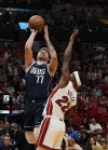 Dallas Mavericks guard Luka Doncic (77) drives to the basket over Miami Heat forward Jimmy Butler (22) during the first half of an NBA basketball game Saturday, April 1, 2023, in Miami. (AP Photo/Marta Lavandier)