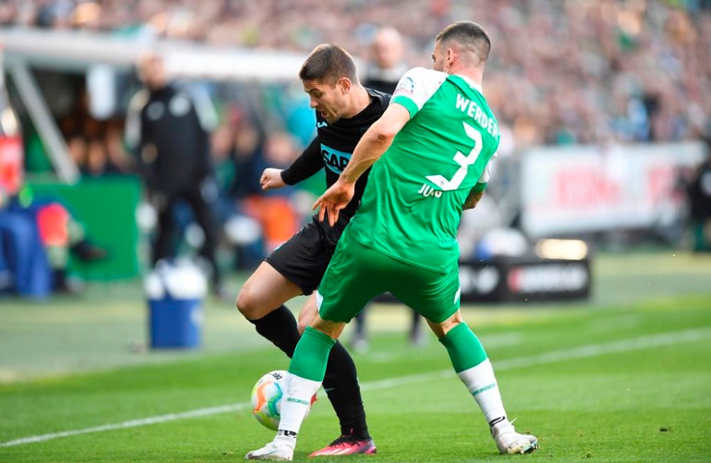 Werder's Anthony Jung takes on Hoffenheim's Andrej Kramaric, left, during the German Bundesliga soccer match between Werder Bremen and TSG 1899 Hoffenheim, in Bremen, Germany, Sunday, April 2, 2023. (Carmen Jaspersen/dpa via AP)