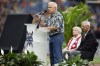 Tom Zimmer, son of the late player and coach Don Zimmer, speaks during a ceremony inducting his father into the Tampa Bay Rays Hall of Fame before a baseball game between the Rays and the Detroit Tigers Sunday, April 2, 2023, in St. Petersburg, Fla. Looking on is Tom's mother Soot and former Rays base coach Tom Foley. (AP Photo/Chris O'Meara)