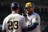 Milwaukee Brewers first baseman Rowdy Tellez, right, talks with Brewers first base coach Quintin Berry after being safe at first after Chicago Cubs third baseman Nick Madrigal dropped the ball during the sixth inning of a baseball game Sunday, April 2, 2023, in Chicago. (AP Photo/Erin Hooley)