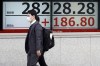 People walk in front of an electronic stock board showing Japan's Nikkei 225 index at a securities firm Monday, April 3, 2023, in Tokyo. Oil prices soared more than 5% after Saudi Arabia and other major oil producers said they will cut production by 1.15 million barrels per day from May until the end of the year. Shares in Asia were mixed on Monday and the dollar rose against the Japanese yen. (AP Photo/Eugene Hoshiko)