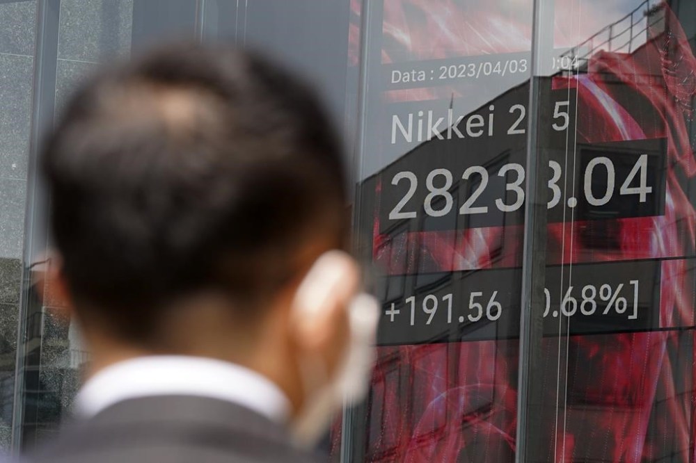 A person looks at an electronic stock board showing Japan's Nikkei 225 index at a securities firm Monday, April 3, 2023, in Tokyo. Oil prices soared more than 5% after Saudi Arabia and other major oil producers said they will cut production by 1.15 million barrels per day from May until the end of the year. Shares in Asia were mixed on Monday and the dollar rose against the Japanese yen. (AP Photo/Eugene Hoshiko)
