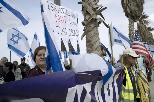FILE - Israeli-Americans gather outside of the U.S. Embassy Branch Office to protest against plans by Prime Minister Benjamin Netanyahu's new government to overhaul the judicial system in Tel Aviv, Israel on March 7, 2023. This year, when the slavery-to-freedom story of Passover unfolds, mass demonstrations in Israel will be top of mind for some Jews around the globe. Some Seder hosts plan to recite portions of the Israel Declaration of Independence. Others will connect the traditional symbols on the Seder plate to divisions over Netanyahu's proposed judicial overhaul. (AP Photo/Maya Alleruzzo, File)