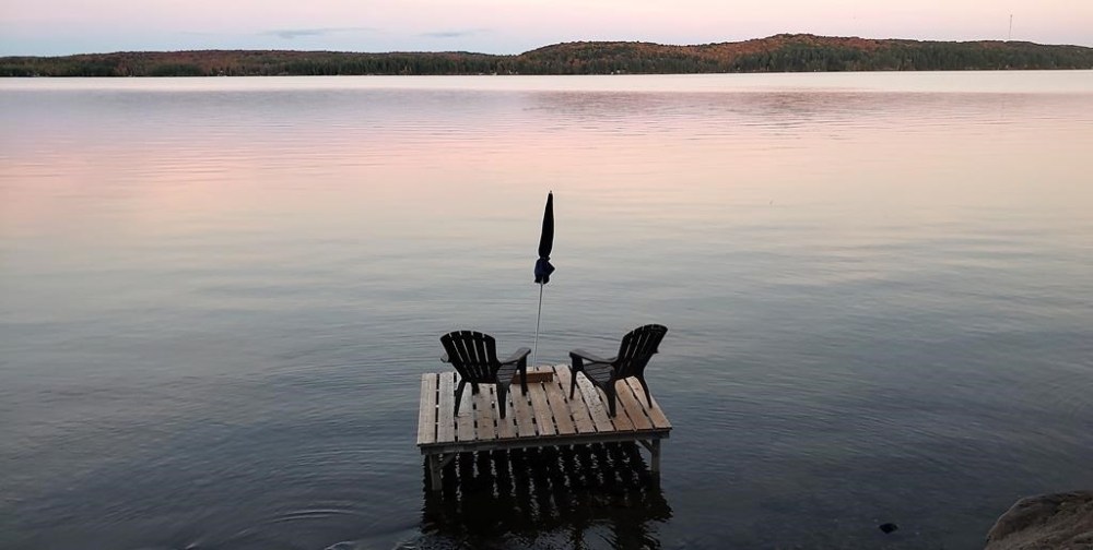 Muskoka chairs sit on a dock looking over Boshkung Lake, in Algonquin Highlands, Ont., Monday, Oct. 5, 2020. THE CANADIAN PRESS/Giordano Ciampini