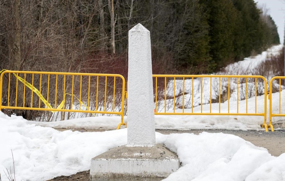 A Canada/US border marker is shown on Roxham road in Hemmingford, Que., Saturday, March 25, 2023. Prime Minister Justin Trudeau is reiterating the importance of an orderly immigration system as police investigate the deaths of eight migrants, including two children, in the Mohawk Territory of Akwesasne last week. THE CANADIAN PRESS/Graham Hughes