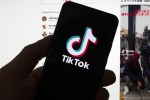 The TikTok logo is seen on a mobile phone in front of a computer screen which displays the TikTok home screen on Saturday, March 18, 2023, in Boston. A growing group of young Canadians rely on self teaching when it comes to personal finance, in the absence of financial literacy being taught in schools and households and with the rise in personal finance content being shared online, but experts caution that it's important to check the credentials of anyone offering advice. THE CANADIAN PRESS/AP-Michael Dwyer