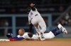 Los Angeles Dodgers' Mookie Betts, bottom, is tagged out, trying to steal second base, by Colorado Rockies shortstop Ezequiel Tovar (14) during the fifth inning of a baseball game Tuesday, April 4, 2023, in Los Angeles. (AP Photo/Marcio Jose Sanchez)