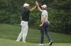 Sam Burns and Scottie Scheffler react on the 11th green during a practice for the Masters golf tournament at Augusta National Golf Club, Tuesday, April 4, 2023, in Augusta, Ga. (AP Photo/Mark Baker)