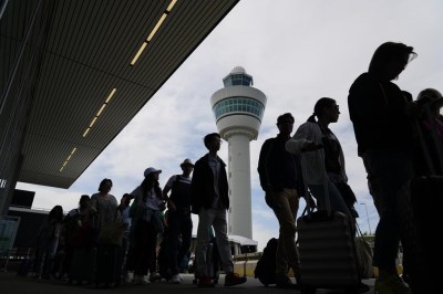 FILE - Travelers wait in long lines outside the terminal building to check in and board flights at Amsterdam's Schiphol Airport, Netherlands, on June 21, 2022. A judge ruled Wednesday April 5, 2023 that the Dutch government cannot order Amsterdam's Schiphol Airport, one of Europe's busiest aviation hubs, to reduce the number of flights from 500,000 per year to 460,000, dealing a blow to efforts to cut emissions and noise pollution.(AP Photo/Peter Dejong, File)