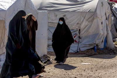 Women walk in Roj detention camp in northeast Syria Wednesday, Feb. 9, 2022. A lawyer working to bring a Quebec woman home from a Syrian prison camp along with her six children says it is 