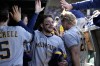 Milwaukee Brewers shortstop Brice Turang getshigh-fives in the dugout after scoring on a single by Brewers left fielder Jesse Winker during the sixth inning of a baseball game against the Chicago Cubs Sunday, April 2, 2023, in Chicago. (AP Photo/Erin Hooley)