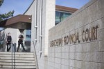 Deputy sheriffs walk into the Saskatchewan Provincial Courthouse in Prince Albert, Sask., on May 13, 2021. The father of a man who was beaten to death in 2016 is accused of killing the man who was charged in his son’s killing. THE CANADIAN PRESS/Kayle Neis