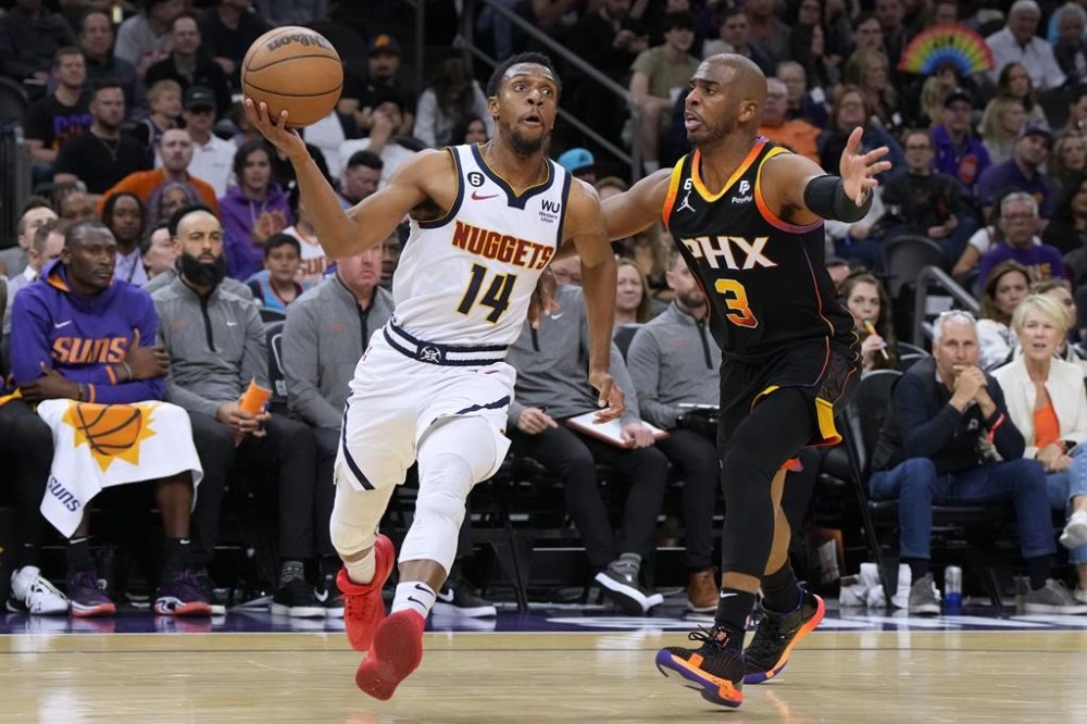 Denver Nuggets guard Ish Smith (14) drives against Phoenix Suns guard Chris Paul during the second half of an NBA basketball game Thursday, April 6, 2023, in Phoenix. (AP Photo/Rick Scuteri)