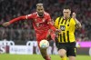 Bayern's Eric Maxim Choupo-Moting, left, is challenged by Dortmund's Niklas Suele during the German Bundesliga soccer match between FC Bayern Munich and Borussia Dortmund at the Allianz Arena stadium in Munich, Germany, Saturday April 1, 2023. (AP Photo/Matthias Schrader)