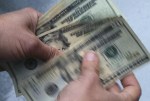 FILE- In this June 15, 2018, file photo, twenty dollar bills are counted in North Andover, Mass. More than half of older taxpayers (57%) are worried they’ll have to pay more taxes this year because of the 5.9% Social Security cost-of-living adjustment in 2022, according to a January survey by The Senior Citizens League. (AP Photo/Elise Amendola, File)