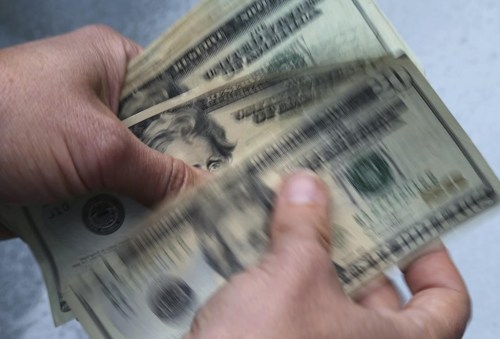 FILE- In this June 15, 2018, file photo, twenty dollar bills are counted in North Andover, Mass. More than half of older taxpayers (57%) are worried they’ll have to pay more taxes this year because of the 5.9% Social Security cost-of-living adjustment in 2022, according to a January survey by The Senior Citizens League. (AP Photo/Elise Amendola, File)