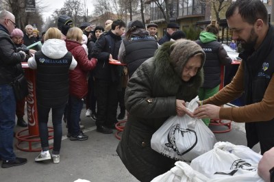 People receive humanitarian aid at a distribution spot in Zaporizhzhya, Ukraine, Friday, April 7, 2023. (AP Photo/Andriy Andriyenko)