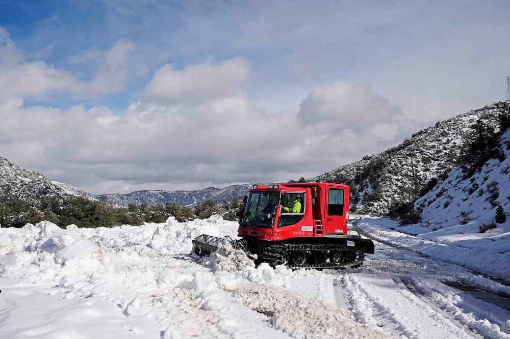 A worker plows snow along State Route 138 near Hesperia, Calif., Wednesday, March 1, 2023. Emergency crews are scrambling to shuttle food and medicine to residents of California mountain communities stranded by back-to-back winter storms. (AP Photo/Jae C. Hong)