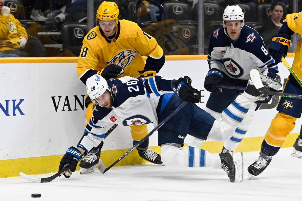 ASSOCIATED PRESS FILES / MARK ZALESKI
Winnipeg Jets center Kevin Stenlund (28) falls in front of Nashville Predators center Cody Glass (8) as they skate after the puck during the first period of a game on March 18.