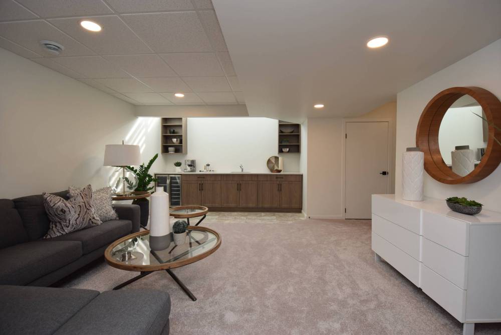 Natural light pours downstairs into the lower level’s living room/media area from a huge, window in the family room above.