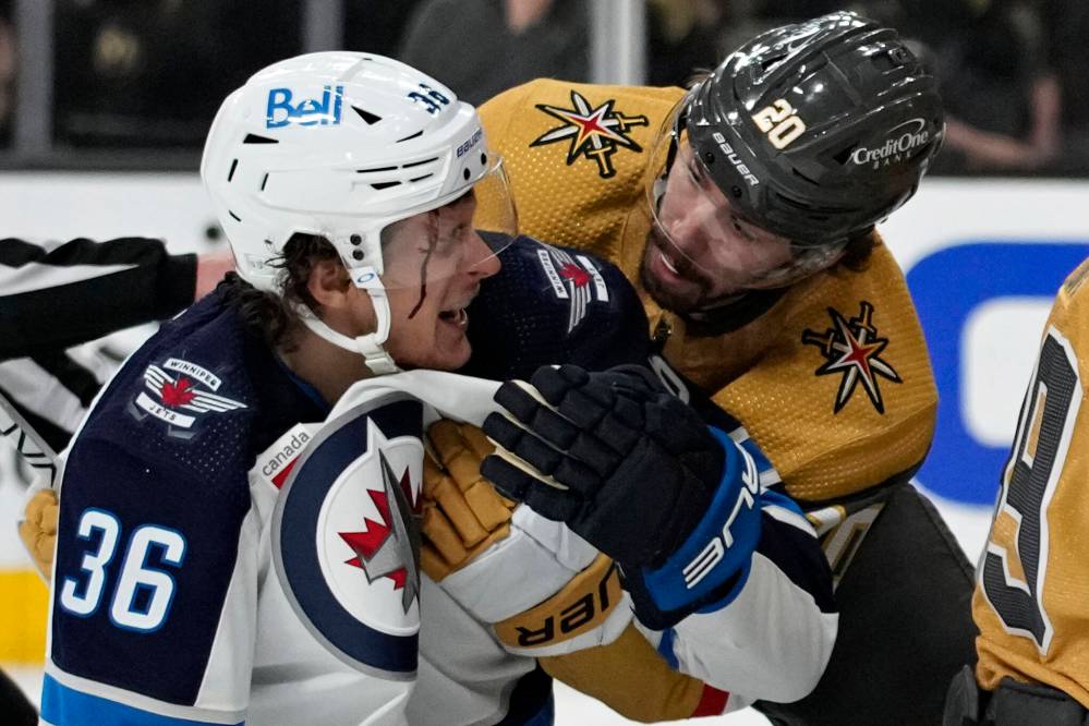 Vegas Golden Knights’ Chandler Stephenson helps Winnipeg Jets’ Morgan Barron after Barron cut his face on a skate during the first period Tuesday in Las Vegas. (AP Photo/John Locher)