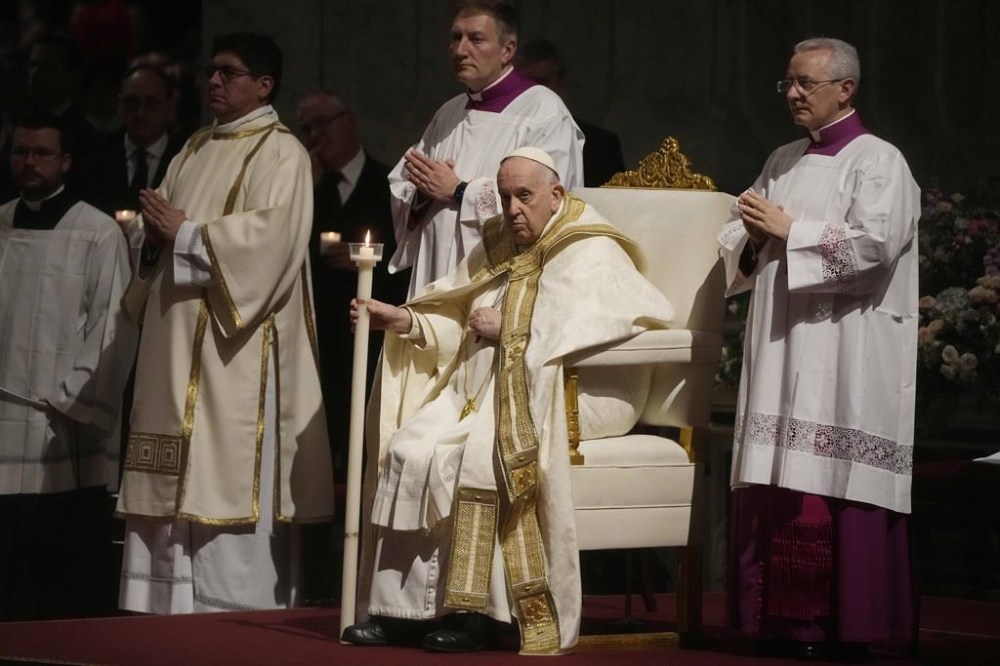 Pope Francis holds a Paschal candle as he presides over a Easter vigil ceremony in St. Peter's Basilica at the Vatican, Saturday, April 8, 2023. (AP Photo/ (AP Photo/Gregorio Borgia)