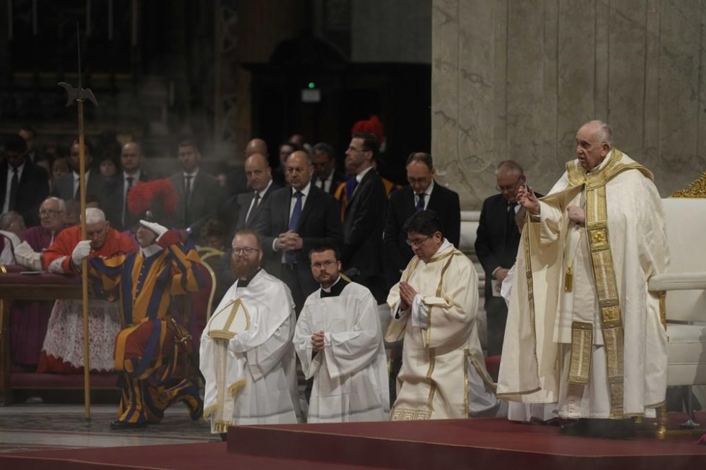 Pope Francis holds a Paschal presides over a Easter vigil ceremony in St. Peter's Basilica at the Vatican, Saturday, April 8, 2023. The service Saturday night in St. Peter's Basilica began in darkness, then dramatically was bathed in light, after a procession up the center aisle by candle-carrying cardinals and other churchmen. (AP Photo/Gregorio Borgia)