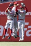Cincinnati Reds center fielder TJ Friedl (29), shortstop Jose Barrero, and left fielder Stuart Fairchild (17) celebrate after their team defeated the Philadelphia Phillies in a baseball game, Sunday, April 9, 2023, in Philadelphia. (AP Photo/Laurence Kesterson)