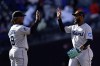 Miami Marlins left fielder Bryan De La Cruz, right, high-fives Jean Segura (9) after the ninth inning of a baseball game against the New York Mets on Sunday, April 9, 2023, in New York. The Marlins won 7-2. (AP Photo/Adam Hunger)