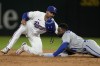 Kansas City Royals' Jackie Bradley Jr., right, advances to second on a flyout by Vinnie Pasquantino as Texas Rangers second baseman Marcus Semien attempts the tag during the eighth inning of a baseball game Tuesday, April 11, 2023, in Arlington, Texas. (AP Photo/Tony Gutierrez)