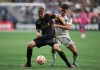 Los Angeles FC's Stipe Biuk, front left, and Vancouver Whitecaps' Sebastian Berhalter vie for the ball during the second half of a CONCACAF Champions League quarterfinal soccer match, in Vancouver, on Wednesday, April 5, 2023. THE CANADIAN PRESS/Darryl Dyck