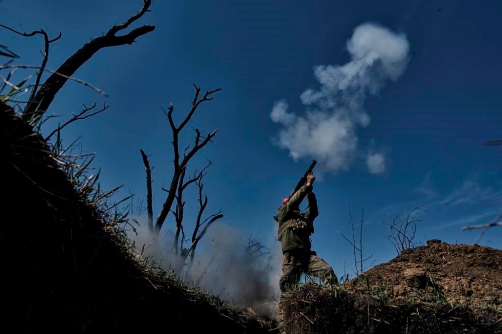 A Ukrainian soldier fires a grenade launcher on the frontline in Bakhmut, Donetsk region, Ukraine, Monday, April 10, 2023. (AP Photo/Libkos)