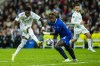 Real Madrid's Vinicius Junior, left, shoots the ball next to Chelsea's Trevoh Chalobah during the Champions League quarter final first leg soccer match between Real Madrid and Chelsea at Santiago Bernabeu stadium in Madrid, Wednesday, April 12, 2023. Real Madrid won 2-0. (AP Photo/Jose Breton)