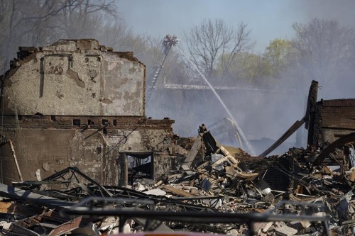 Firefighters pour water on an industrial fire in Richmond, Ind., Thursday, April 13, 2023. Multiple fires that began burning Tuesday afternoon were still burning within about 14 acres of various types of plastics stored inside and outside buildings at the former factory site. (AP Photo/Michael Conroy)