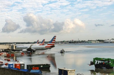American Airlines airplanes sit at terminal as a truck drives through the flooded tarmac at the Fort Lauderdale-Hollywood International Airport on Thursday, April 13, 2023, Fort Lauderdale, Fla. (David Santiago/Miami Herald via AP)