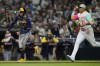 Milwaukee Brewers' Owen Miller, left, is chased by San Diego Padres third baseman Manny Machado before being tagged out at home on a rundown during the fourth inning of a baseball game Friday, April 14, 2023, in San Diego. (AP Photo/Gregory Bull)