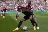 West Ham's Michail Antonio is challenged by Arsenal's Gabriel, front, during the English Premier League soccer match between West Ham United and Arsenal at the London stadium in London, Sunday, April 16, 2023. (AP Photo/Kirsty Wigglesworth)
