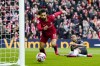 Liverpool's Mohamed Salah, center, celebrates after scoring his side's opening goal during the English Premier League soccer match between Liverpool and Arsenal at Anfield in Liverpool, England, Sunday, April 9, 2023. (AP Photo/Jon Super)
