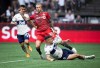 Vancouver Whitecaps' Lucas Cavallini, front right, slides to take the ball away from Toronto FC's Federico Bernardeschi (10) during the first half of the Canadian Championship soccer final, in Vancouver, on Tuesday, July 26, 2022. THE CANADIAN PRESS/Darryl Dyck
