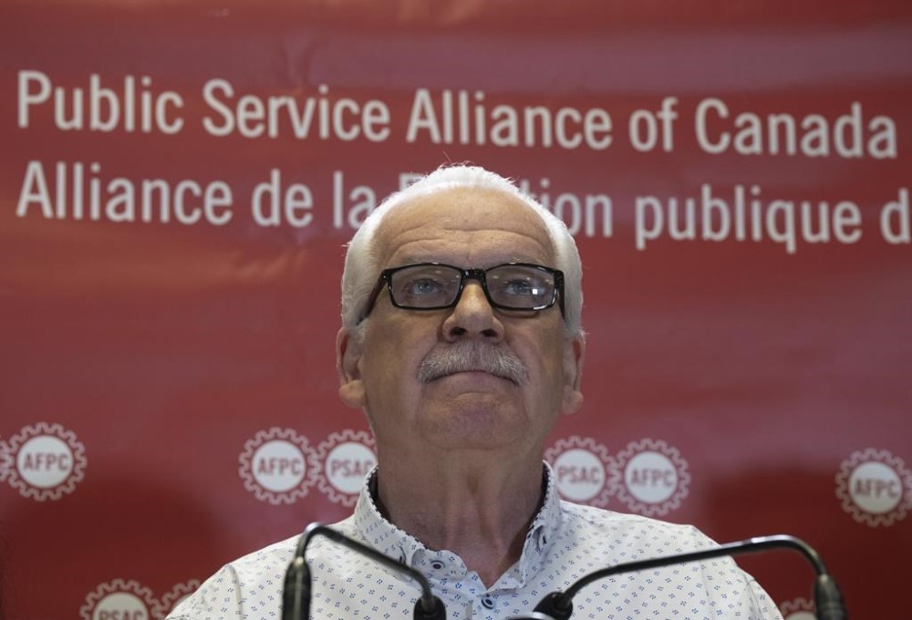 Public Service Alliance of Canada National President Chris Aylward looks up as he listens to a journalist ask a question on the phone during a news conference at union headquarters, Monday, April 17, 2023 in Ottawa. If the federal government and Canada's largest union does not reach a deal by 9 p.m. EDT tonight, the union says they already have an action plan ready for Wednesday's strike. THE CANADIAN PRESS/Adrian Wyld