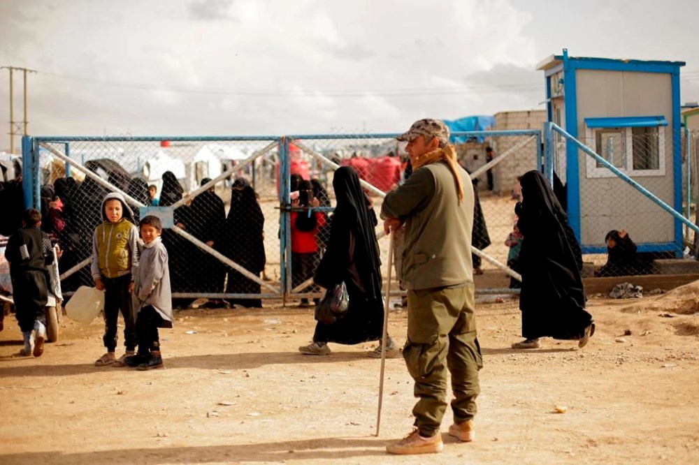Children watch a Kurdish guard at Al-Hol camp, at the gate to the section where foreign families from Islamic State-held areas are housed, in Hassakeh province, Syria on March 31, 2019.The lawyer for two Canadian women and three teenage girls who were set to be repatriated from northeastern Syria earlier this month says they were mistreated by guards and are still being detained in a camp primarily holding family members of individuals with alleged links to ISIS or Daesh. THE CANADIAN PRESS/AP, Maya Alleruzzo