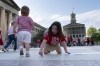 Mabel Weiss draws on the floor of Legislative Plaza during a demonstration for gun control legislation Tuesday, April 18, 2023, in Nashville, Tenn. Participants created a human chain spreading from Monroe Carell Jr. Children's Hospital at Vanderbilt, where victims of The Covenant School shooting were taken on March 27, to the Tennessee State Capitol. (AP Photo/George Walker IV)