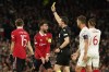 Manchester United's Bruno Fernandes, 2nd left, reacts after receiving yellow card during the Europa League first leg quarterfinal soccer match between Manchester United and Sevilla at the Old Trafford stadium in Manchester, Thursday, April 13, 2023. (AP Photo/Dave Thompson)