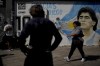 People attend a protest demanding more government social programs near a mural of late soccer star Diego Maradona on the outskirts of Buenos Aires, Argentina, Wednesday, April 5, 2023. Argentina has one of the highest inflation rates in the world. (AP Photo/Natacha Pisarenko)