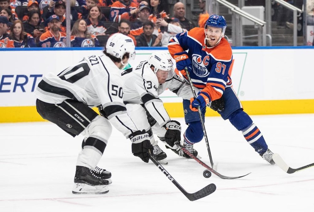 Los Angeles Kings' Sean Durzi (50) and Arthur Kaliyev (34) try to stop Edmonton Oilers' Connor McDavid (97) during second period NHL Stanley Cup first round playoff action in Edmonton on Wednesday April 19, 2023. THE CANADIAN PRESS/Jason Franson
