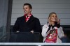 Rob McElhenney, left, and his wife Kaitlin Olson take their places in the stands at Wrexham's Racecourse Ground before the National League soccer match between Wrexham and Yeovil Town in Wrexham, Wales, Tuesday, April 18, 2023. It's hard to imagine that even A-list owners Ryan Reynolds and Rob McElhenney anticipated the unscripted drama created by this unlikely union between Tinseltown and a former mining town in Wales. (AP Photo/Jon Super)