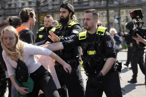 A police officer pushes a protestor away as police try to stop a march by activists of the 