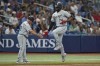 Chicago White Sox's Eloy Jimenez (74) celebrates with third base coach Eddie Rodriguez (18) after hitting a solo home run off Tampa Bay Rays relief pitcher Cooper Criswell during the fourth inning of a baseball game Friday, April 21, 2023, in St. Petersburg, Fla. (AP Photo/Chris O'Meara)